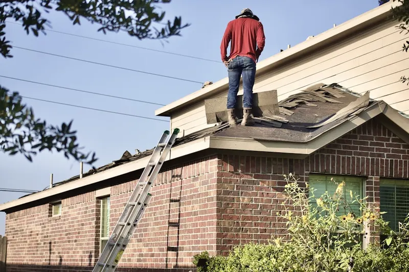 Professional roofer working on a residential roof in West Liberty